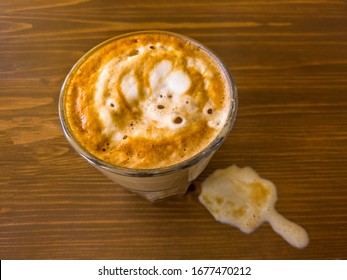 Next To A Cup Of Coffee On The Table Is Visible Snag Milk Foam With Veins Of Coffee Color, The View From Above