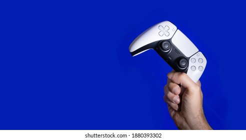 Next Gen game controller on mans hands - Shutterstock ID 1880393302