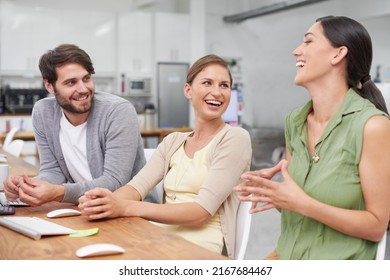 Next Generation Techies. Shot Of A Group Of Young Businesspeople Enjoying A Laugh Together At Their Desk.