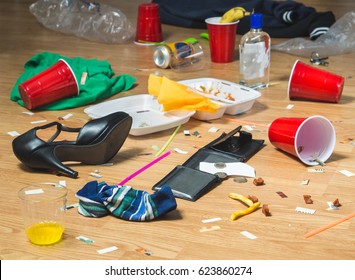 Next Morning To A Party. Horrible Mess And Chaos After Crazy Night At Partying And Drinking. Trash, Bottles, Food, Cups And Clothes On The Floor. Messy Hangover Or Drinker's Remorse Concept.