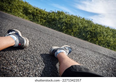 Next time I should train before I run a marathon. an exhausted runners legs as he sits next to the road.