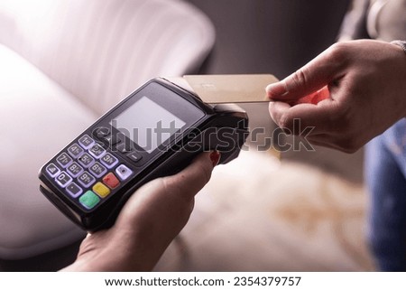 NFC credit card payment. Woman paying with contactless credit card with NFC technology. Wireless money transaction. Card machine in male hand on sunlight background