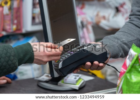 NFC technology, customer do payment with contactless credit card. Credit card reader implements payment execution, in the shop