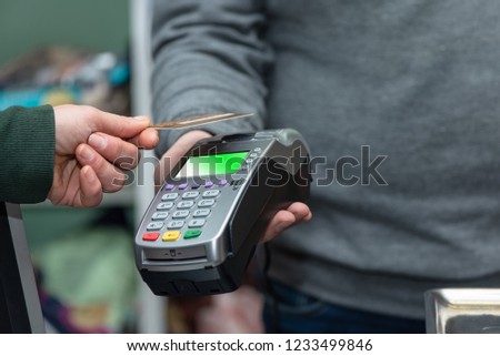 NFC technology, customer do payment with contactless credit card. Credit card reader implements payment execution, in the shop