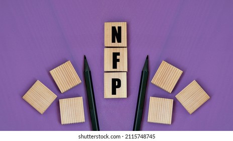 NFP (Natural Family Planning) - Acronym On Wooden Cubes With Pencils On A Purple Background