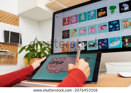 NFT artist painting on a digital tablet in his home office