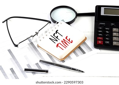 NFT TIME text on a notebook with calculator on diagram background