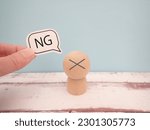 NG word on the speech bubble held by batten and finger on the doll