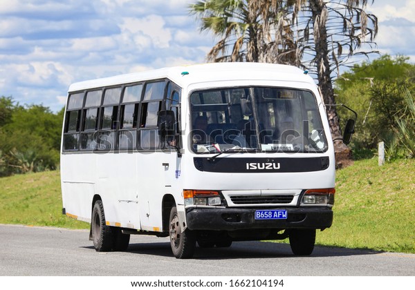 Ngamiland, Botswana - February 9,\
2020: White Isuzu Elf based intercity bus at the interurban\
road.