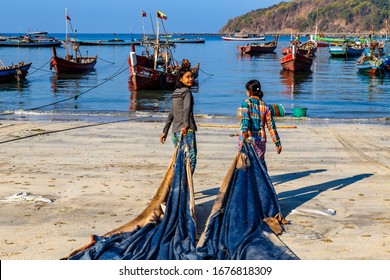 NGAPALI, MYANMAR - FEBRUARY 10, 2020 : Fisherman Village. Women Working At Drying Fish. Low Income Life, Down To Earth.