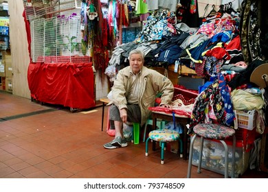 Ngau Chi Wan, Kowloon, Hong Kong - 12 Dec 2017: An Old Man As A Shop Keeper Sitting In Front Of His Own Store In The Chinese Market.