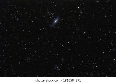 NGC 7331 galaxy and cluster of galaxies photographed with long exposure through a telescope.