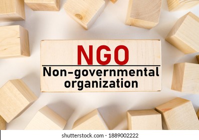 NGO, non-governmental organization. Text on wood block on white background - Shutterstock ID 1889002222