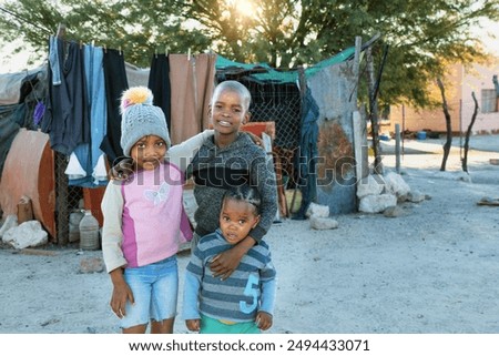 NGO organizations helping with poverty issues in the african village, african siblings holding each other in front of the washing line.