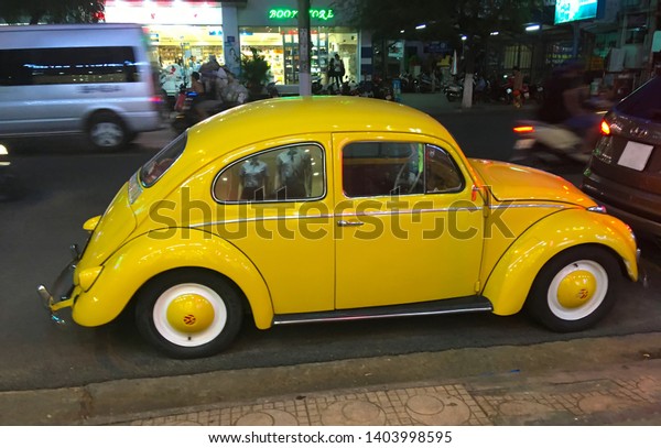 Nha\
Trang, Vietnam - 4 April, 2019: Old yellow Volkswagen beetle \'Bug\'\
or Volkswagen Type 1 is parked on the night\
street.