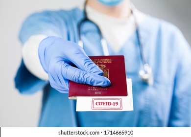 NHS Doctor Holding Passport With COVID-19 Sign Stamped Onto White Paper,immunity Passport Risk-free Certificate Concept,recovered Coronavirus COVID19 Patients Being Issued Proof Of Convalescence,UK ID