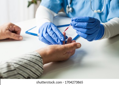 NHS UK doctor taking patient blood sample,serologic finger prick PRP blood antibodies test to determine whether person developed immunity to novel Coronavirus,global COVID-19 pandemic health crisis