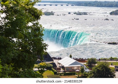 Niagara Falls, Canada - August 27, 2021: View of the impressive Niagara Falls. Horseshoe falls from the Canadian side. Massive water falls under the cloudy sky. View from the Incline Railway 