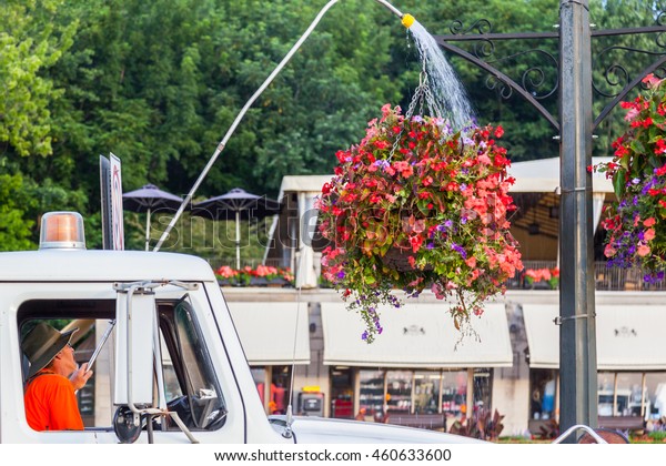 NIAGARA FALLS, ONTARIO, CANADA - JULY 23,\
2016: Staff driving water truck watering hanging flower baskets in\
Niagara park, Ontario,\
Canada\
\
