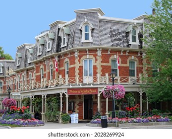 Niagara-on-the-Lake, Ontario, Canada - August 16, 2021:   Old Victorian hotel in Niagara-on-the-Lake, Ontario, with colorful floral decorations on the street in summer.