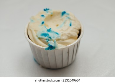 A Nibbled Or Spoiled Cream Cake In A Cardboard Basket On A White Table. The Concept Of Baking And Confectionery