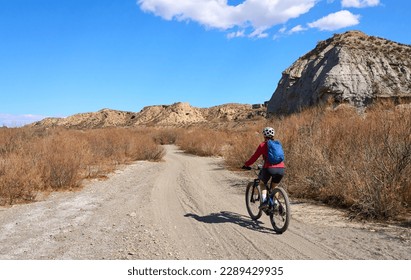 nice, active senior woman with her electric mountain bike on a trail tour in the desert of Tabernas near Almeria, Andlusia, Spain - Powered by Shutterstock