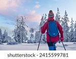 nice and active senior woman hiking with snow shoes in deep powder snow in the  Hochhaedrich area of Bregenz Forest in Vorarlberg, Austria
