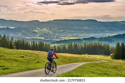 Nice Active Senior Woman Riding Her Electric Mountain Bike At Mount Gruenten In The Allgaeu Alps , Bavaria, Germany