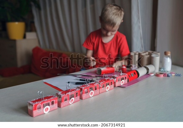 Nice advent calendar like ski resort or train.\
Little boy makes crafted advent calendar with rolls from toilette\
paper. Funicular advent calendar. Zero waste and reusable\
lifestyle. Seasonal\
holiday