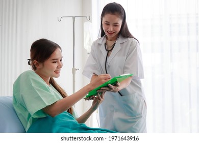 Nice Asian Female Doctor Using Stethoscope To Check On Her Young Patient Woman Heartbeat And Lung In The Hospital. Health Care And Medical Concept