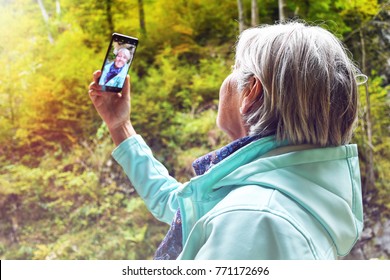 Nice Attractive Elderly Mature Woman With Shiny Grey Hair Taking Photos And Selfies Outdoor In A Vintgar River Canyon Gorge On A Beautiful Sunny Autumn Day