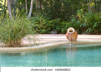 A Nice Backyard Swimming Pool With A Water Feature Vase