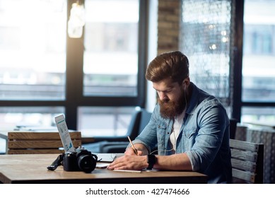 Nice  bearded man sitting at the table   