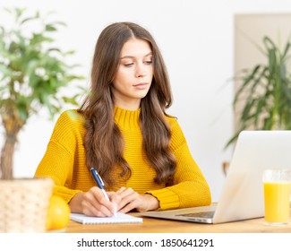 Nice Beautiful Female With Blonde Long Hair Working On Laptop Sitting At Home. Online Shoping, Alternative Office Freelance, Gig Economy, Digital Nomad