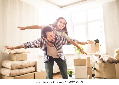 Nice and beautiful picture of father and daughter spending time together. Girl is lying on her dad's back and pretending she is flying. Her dad is doing the same thing. Both of them are happy. - Powered by Shutterstock