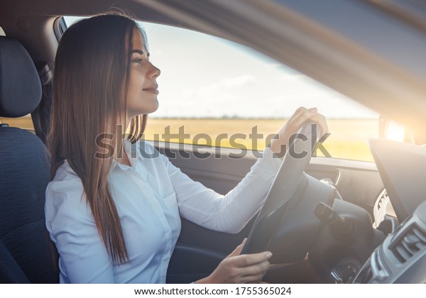 Nice\
business woman driving a car without a safe\
belt.