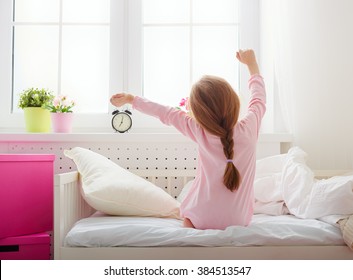 A Nice Child Girl Enjoys Sunny Morning. Good Morning At Home. Child Girl Wakes Up From Sleep.