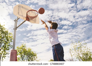 A nice and cool Afro american players playing basketball outdoors - Powered by Shutterstock