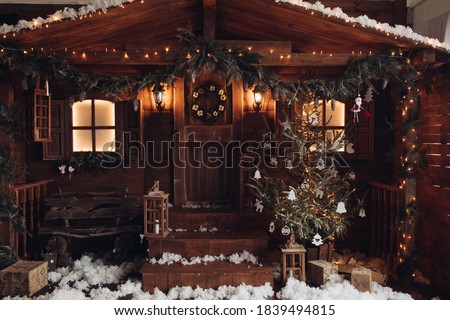 A nice cozy yard decorated for the New Year with a christmas tree, a garland, tinsel and lanterns