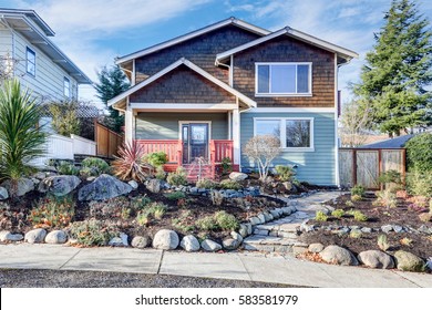 Nice Craftsman Home Exterior On Blue Sky Background. Well Kept Frontyard With Natural Stone Landscape Design. Northwest, USA