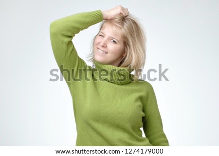 Nice cute blonde girl teenage wearing green sweater with beautiful healthy skin smiling looking at camera.