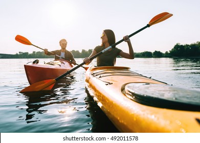 Nice day on the lake. Beautiful young couple kayaking on lake together and smiling  - Powered by Shutterstock