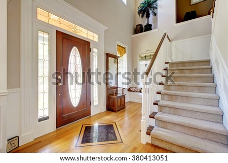 Nice entry way to home with carpet staircase and white interior.