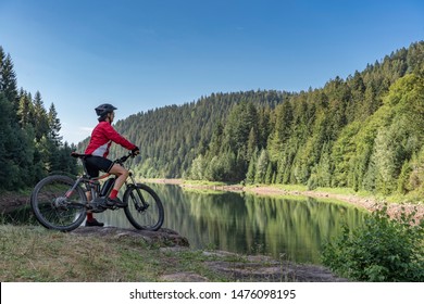 nice and ever young senior woman with her electric mountain bike at the Kinzig drinking Water reservoir in the northern Black Forest, Baden-Wuerttemberg, Germany - Powered by Shutterstock