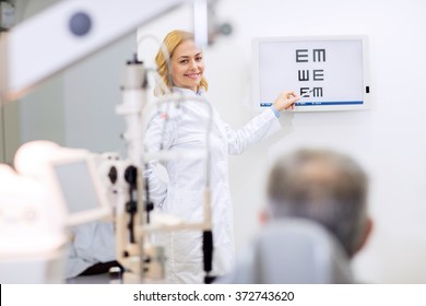 Nice Female Blonde Eye Doctor Show Letters In Consulting Room 