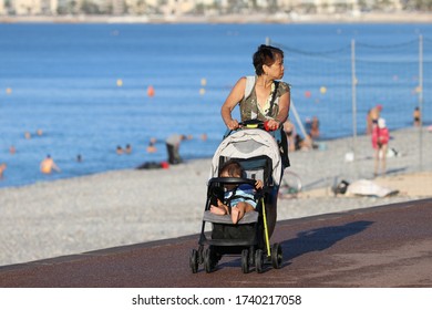 Nice, France 8/16/2018  Promenade Des Anglais. Asian Woman With Baby Carriage On The Promenade