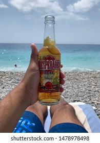Nice, France - August 1 2019: Desperado's Beer a very popular tequila infused beer popular during the summer time being drunk on the beach with crystal blue water