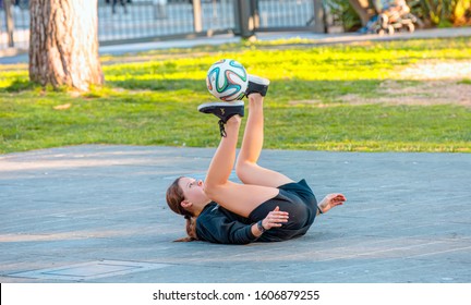 NICE, FRANCE - DECEMBER 30 2019: Young Girl Soccer Player On The Street - A Girl Plays With The Soccer Ball Alone On A Street Soccer