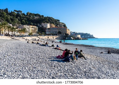 Nice, France, January 2020 - People Enjoy A Sunny Winter Day At Ponchettes Beach In Nice