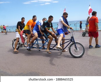 NICE, FRANCE - Jul 08, 2013: Friends Having Fun In A Tandem Bike At Nice Beach In South France